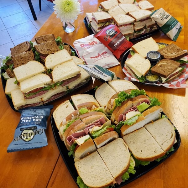 Multiple deli sandwich platters with chips and cookies from Lake Wales Cheese Shoppe & Deli.