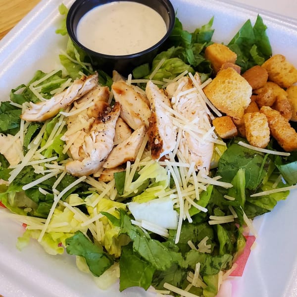 A Caesar salad from Lake Wales Cheese Shoppe & Deli with grilled chicken, croutons, and dressing.